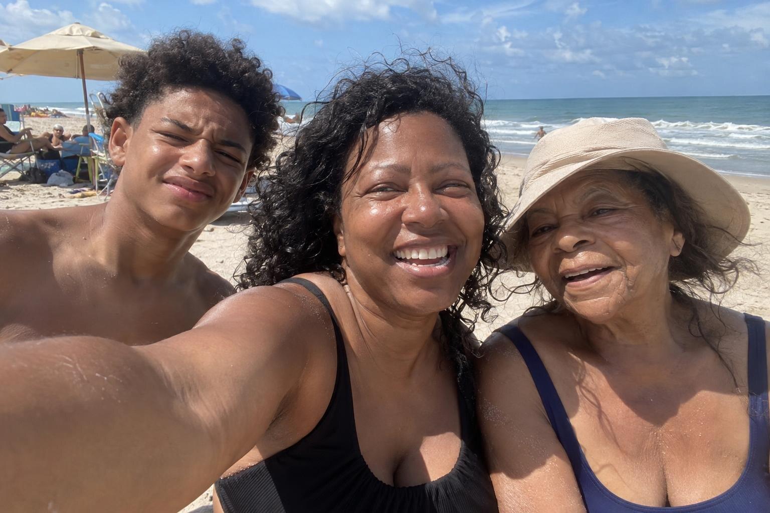 A mum, her teenage son and her mother squeezed into a selfie on a sunny beach.
